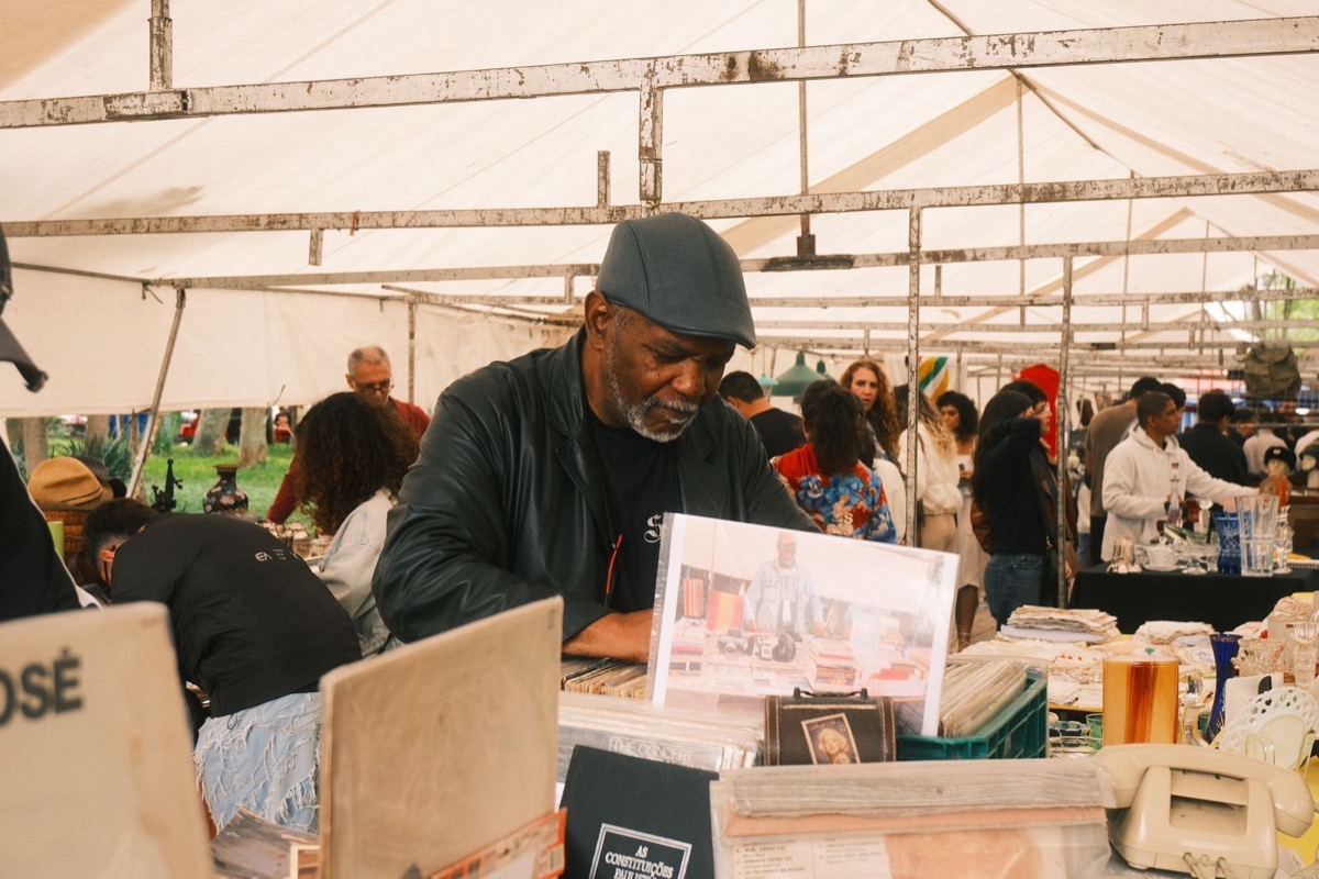 Busy indoor market floor with vendor tables and shoppers browsing